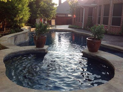 A pool with two large pots of plants in it.